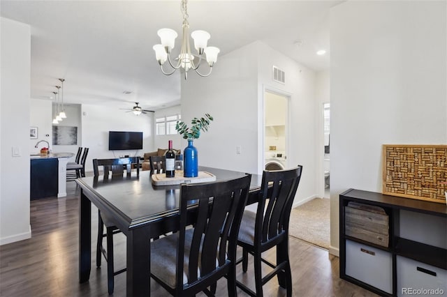 dining space with dark wood-style flooring, washer / clothes dryer, visible vents, baseboards, and ceiling fan with notable chandelier