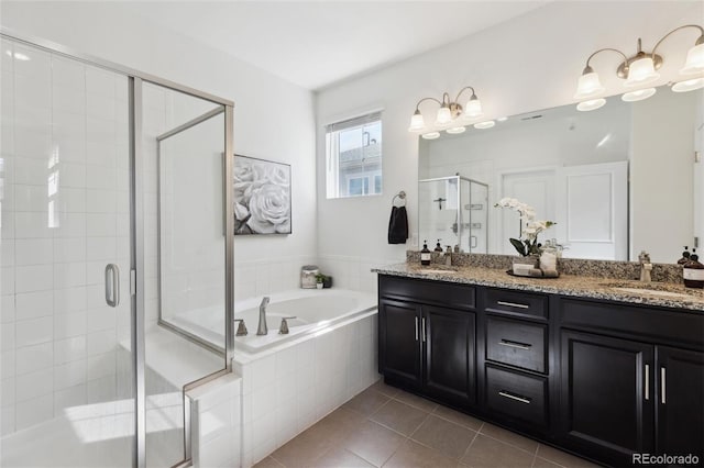 full bath with double vanity, a stall shower, a sink, tile patterned flooring, and a bath