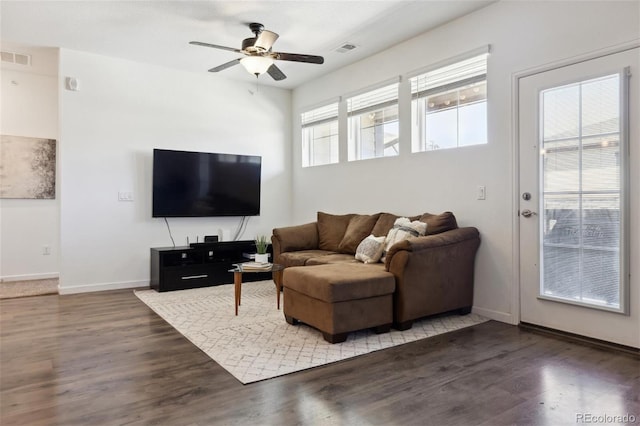 living area featuring wood finished floors, visible vents, and baseboards