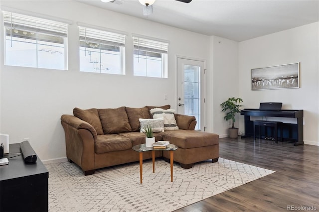 living room featuring a ceiling fan, baseboards, and wood finished floors