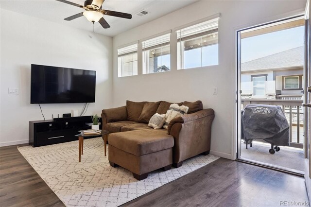 living room with visible vents, baseboards, and wood finished floors