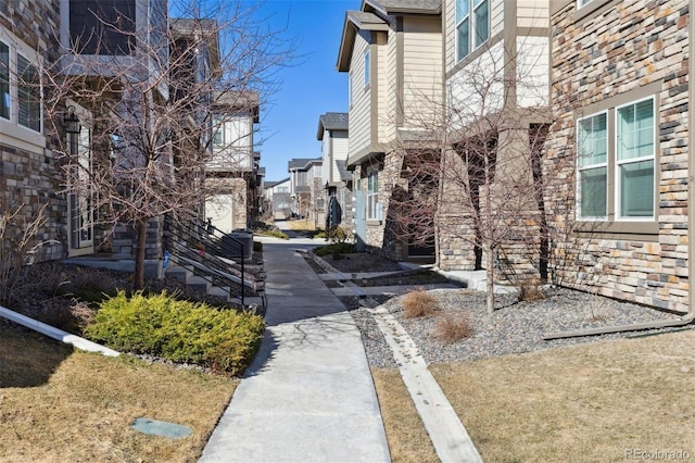 exterior space featuring stone siding and a residential view