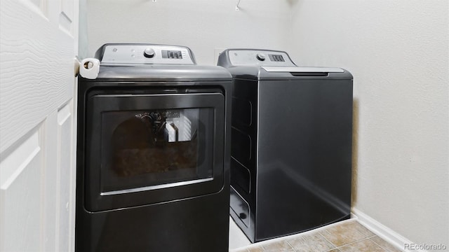 laundry area with light tile patterned floors and washing machine and dryer