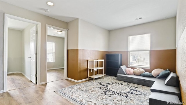 living area with plenty of natural light and light wood-type flooring