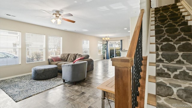 tiled living room featuring ceiling fan with notable chandelier