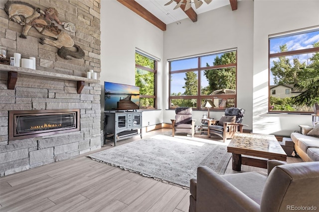 living room with a fireplace, beam ceiling, high vaulted ceiling, and ceiling fan