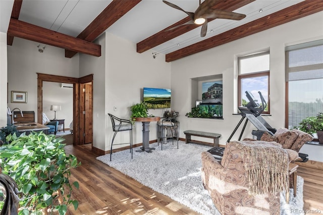 sitting room featuring hardwood / wood-style flooring, ceiling fan, beam ceiling, and sink