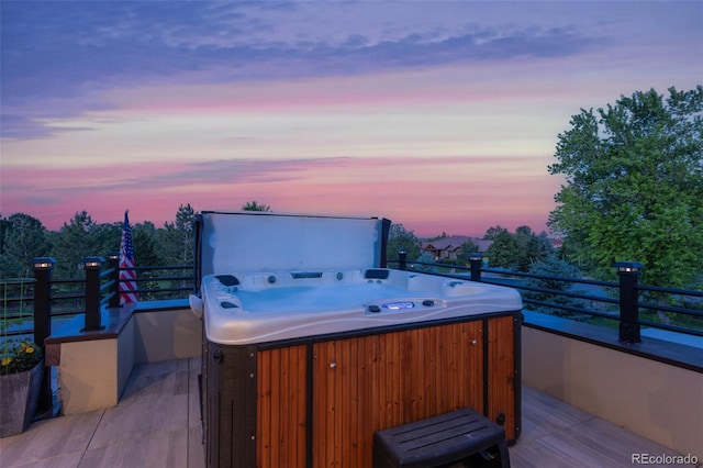 deck at dusk with a hot tub