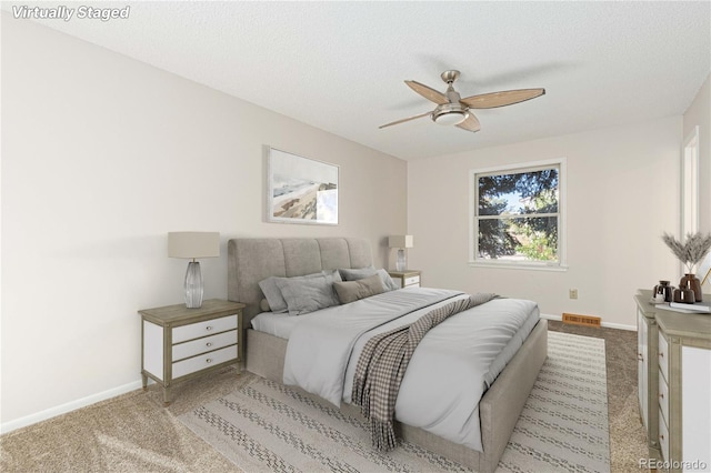 carpeted bedroom with a textured ceiling and ceiling fan