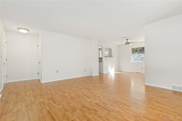 unfurnished room featuring a textured ceiling, light hardwood / wood-style floors, and ceiling fan