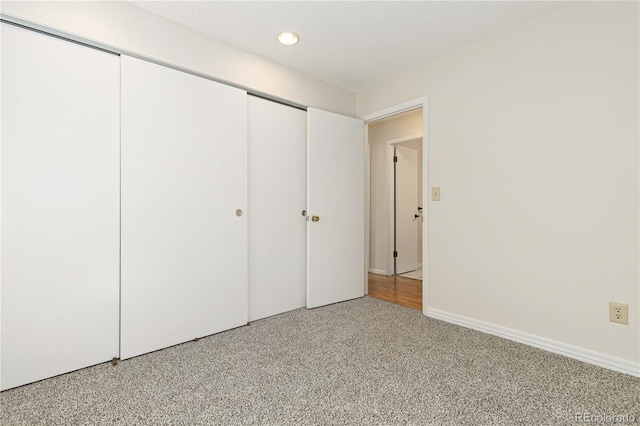 unfurnished bedroom featuring a closet, a textured ceiling, and carpet flooring