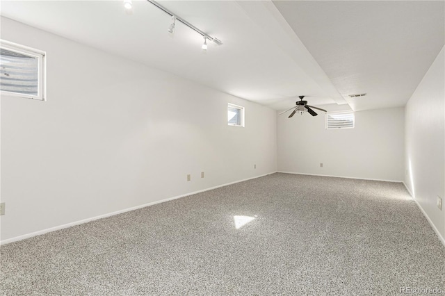 spare room featuring track lighting, carpet floors, and ceiling fan