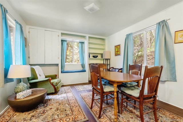 dining room with baseboards, plenty of natural light, and wood finished floors