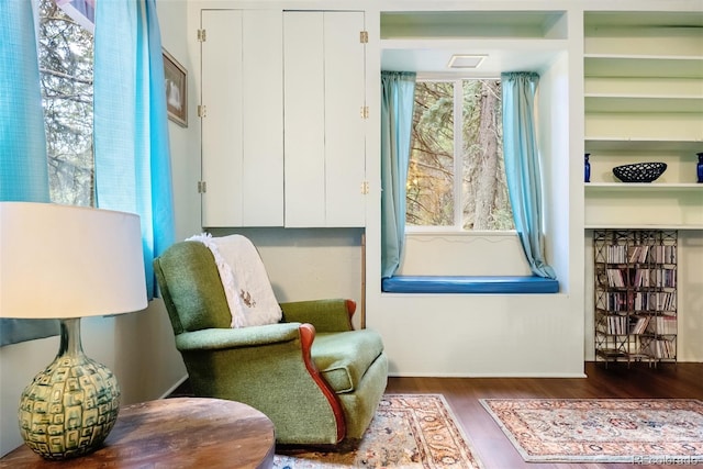 living area with baseboards and wood finished floors