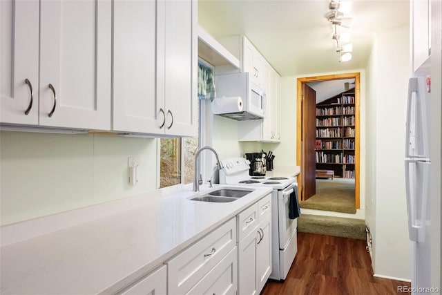 kitchen with white cabinets, dark wood-style flooring, a sink, white appliances, and light countertops