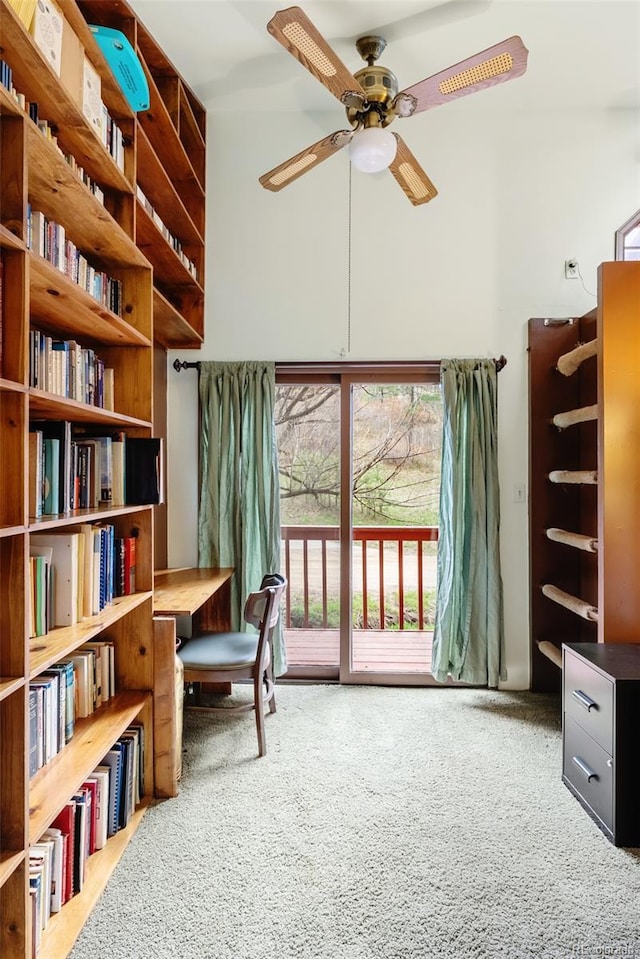 sitting room with carpet floors, a high ceiling, and a ceiling fan