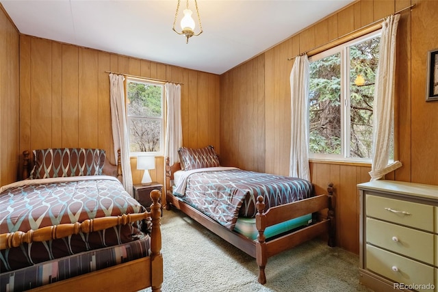 bedroom with carpet flooring and wooden walls