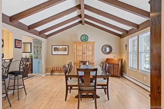 dining room featuring lofted ceiling with beams, a baseboard radiator, and light hardwood / wood-style floors