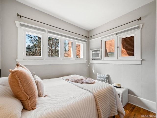 945 N Washington St Unit 201, Denver, CO 80203 - bedroom with wood finished floors, multiple windows, cooling unit, and baseboards