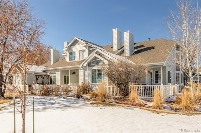 cape cod home featuring covered porch