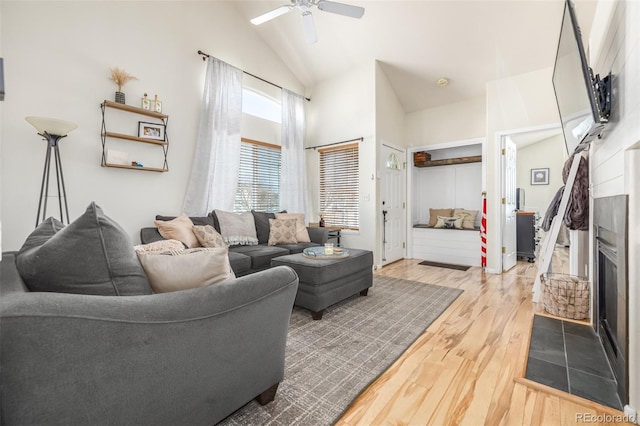 living room featuring vaulted ceiling, ceiling fan, a fireplace, and hardwood / wood-style floors