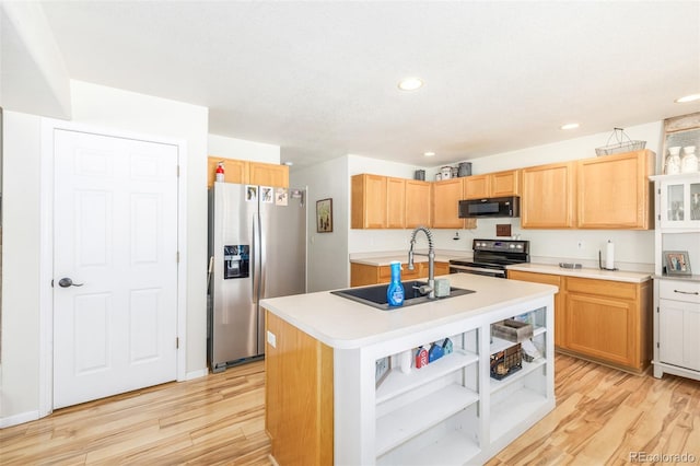 kitchen with a kitchen island with sink, electric range, stainless steel fridge, and light hardwood / wood-style floors