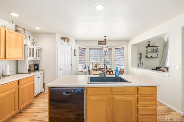 kitchen with sink, black dishwasher, an island with sink, and decorative light fixtures