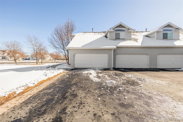 view of snow covered exterior with a garage