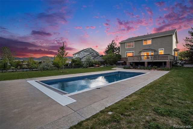 7624 Russell Ct, Arvada, CO 80007 - pool at dusk with an outdoor pool, a lawn, and a deck