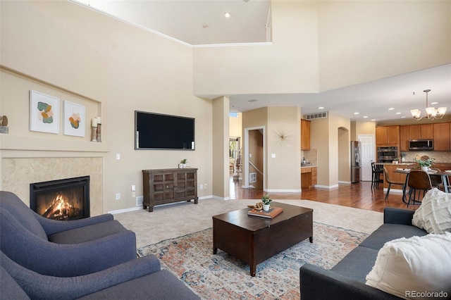 7624 Russell Ct, Arvada, CO 80007 - living area with baseboards, a chandelier, a premium fireplace, a high ceiling, and recessed lighting