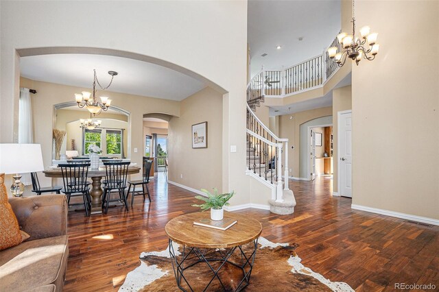 7624 Russell Ct, Arvada, CO 80007 - living area featuring a chandelier, wood finished floors, arched walkways, stairs, and baseboards