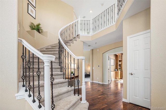 7624 Russell Ct, Arvada, CO 80007 - foyer with wood finished floors, arched walkways, a high ceiling, stairway, and baseboards