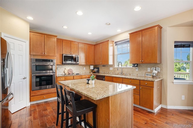 7624 Russell Ct, Arvada, CO 80007 - kitchen with a sink, black appliances, dark wood finished floors, tasteful backsplash, and recessed lighting