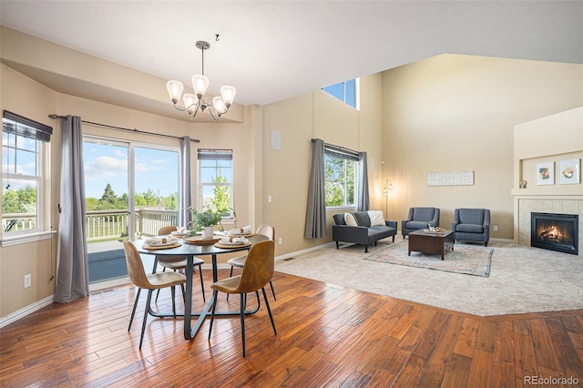 7624 Russell Ct, Arvada, CO 80007 - dining area with hardwood / wood-style floors, a chandelier, baseboards, and high vaulted ceiling