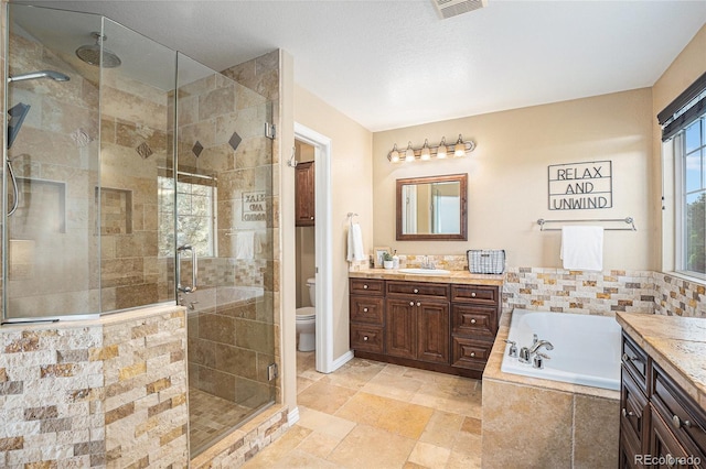 7624 Russell Ct, Arvada, CO 80007 - bathroom with vanity, a garden tub, a shower stall, and toilet