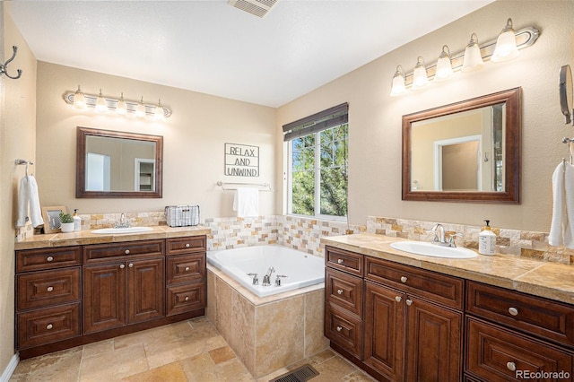 7624 Russell Ct, Arvada, CO 80007 - bathroom featuring two vanities, a garden tub, and stone finish flooring