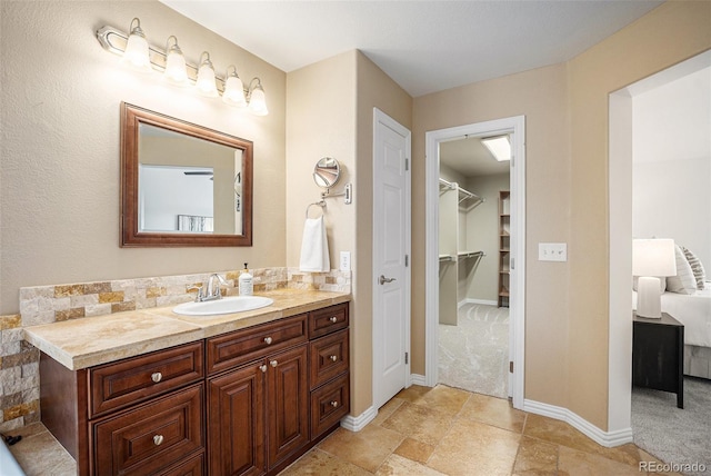 7624 Russell Ct, Arvada, CO 80007 - ensuite bathroom with vanity, baseboards, and a spacious closet
