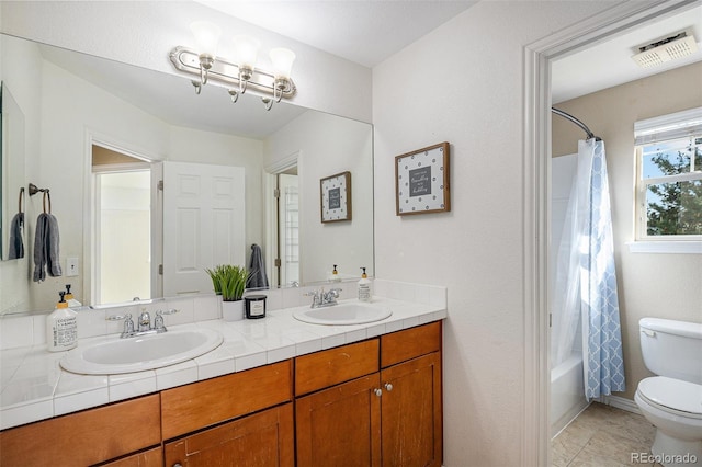 7624 Russell Ct, Arvada, CO 80007 - full bathroom with toilet, double vanity, tile patterned floors, and shower / tub combo