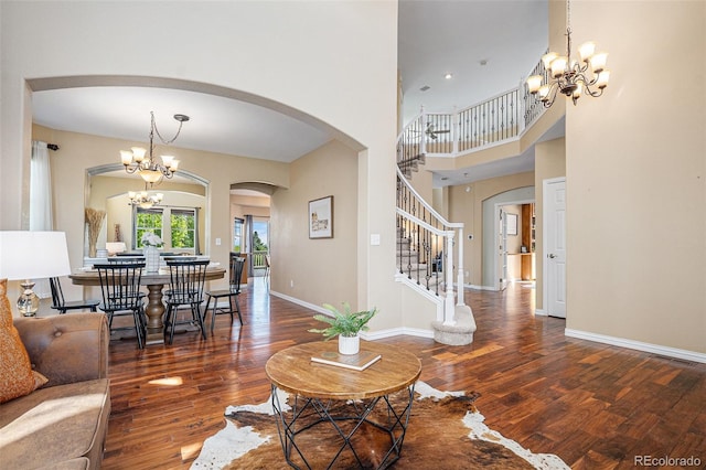 7624 Russell Ct, Arvada, CO 80007 - living area featuring a chandelier, wood finished floors, arched walkways, stairway, and a towering ceiling