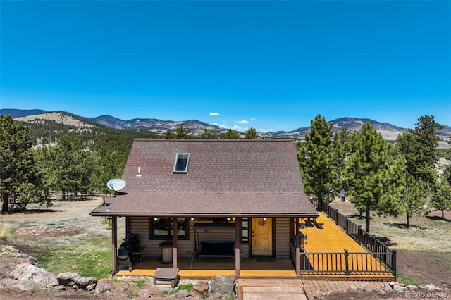 view of front of house with a mountain view, covered porch, and roof with shingles