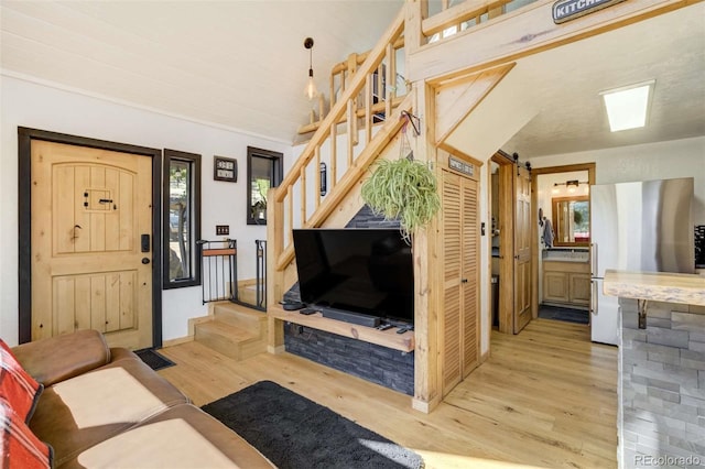 living room featuring stairs, light wood-style floors, and a barn door