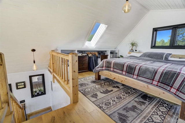 bedroom featuring vaulted ceiling, a skylight, and wood-type flooring