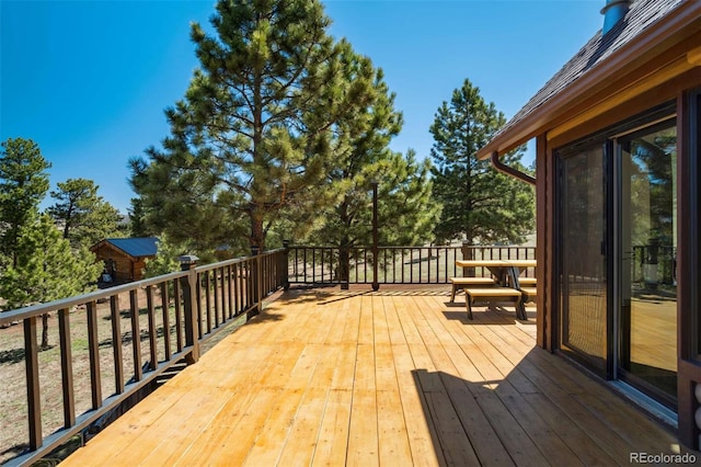 wooden terrace featuring an outbuilding