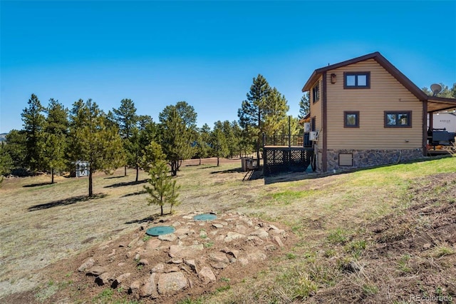 view of property exterior with a wooden deck and a lawn