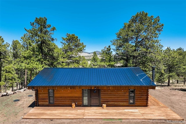 view of front of property with metal roof and a deck with mountain view