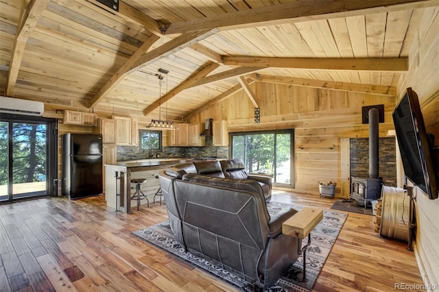 living room with light wood finished floors, wood ceiling, a wood stove, a wall mounted air conditioner, and wood walls