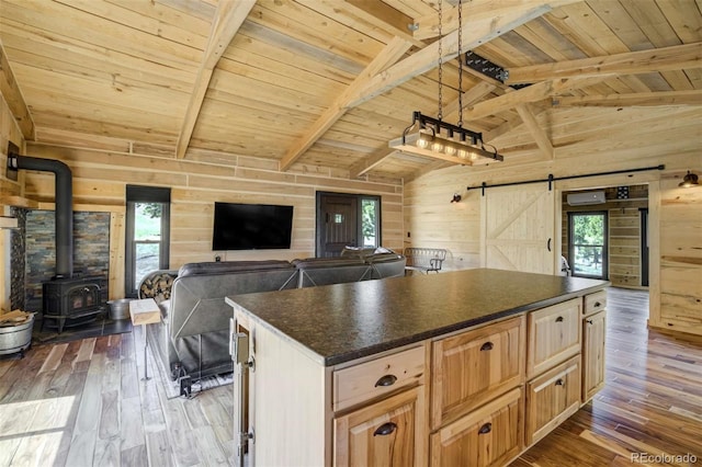 kitchen with wooden walls, a barn door, open floor plan, wooden ceiling, and dark countertops