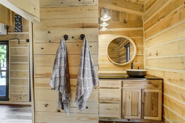 mudroom featuring wood walls, a sink, and wood finished floors