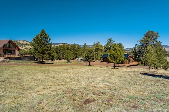 view of green lawn with a mountain view