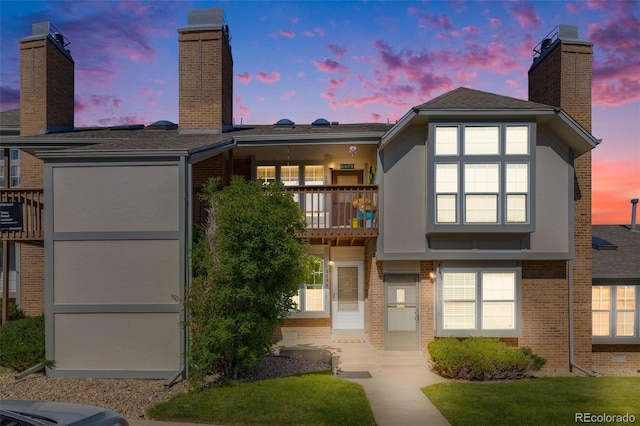 3090 W 107th Pl Unit F, Westminster, CO 80031 - back of house featuring a chimney, brick siding, a balcony, and stucco siding